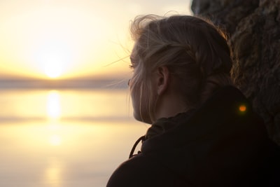 女人黑色连帽衫盯着大海日落时分
